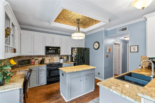 a kitchen with granite countertop a sink stove and refrigerator