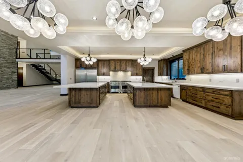 a large room with wooden floor pool table and chairs