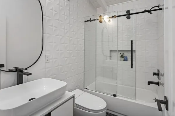 a bathroom with a sink a toilet and shower