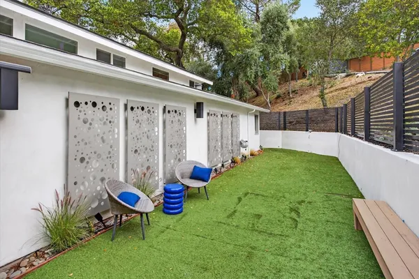 a view of a backyard with table and chairs and wooden fence