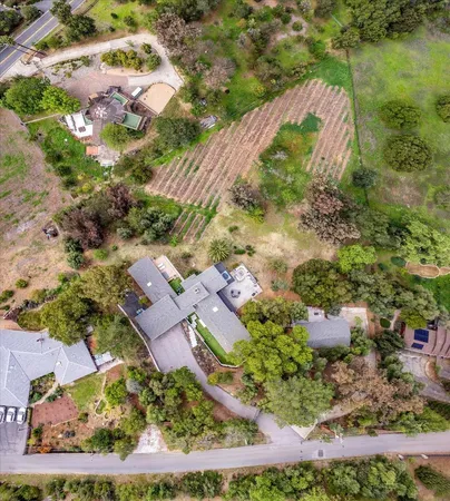 an aerial view of residential houses with outdoor space and trees