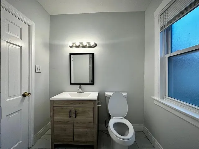 a bathroom with a toilet a sink and mirror