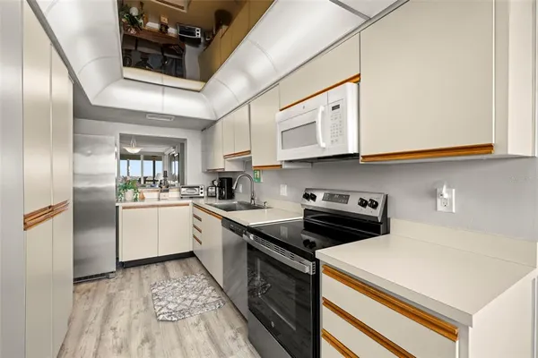 a kitchen with a sink appliances and cabinets