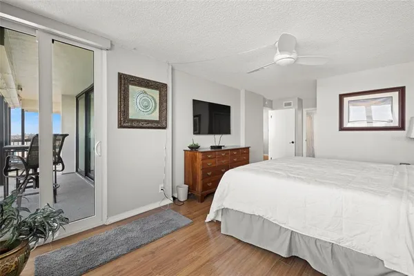 a spacious bedroom with a bed and a flat screen tv