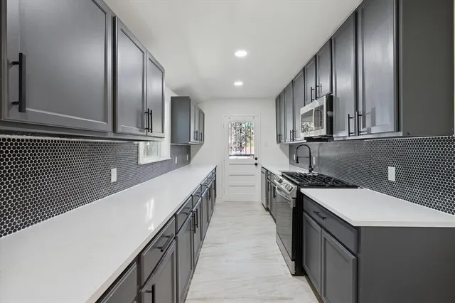 a kitchen with stainless steel appliances a sink and cabinets