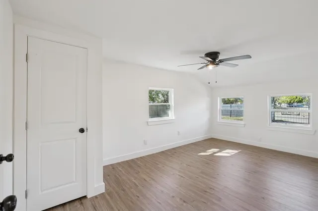 a view of a big room with wooden floor and a chandelier fan