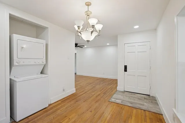 a view of a room with wooden floor and chandelier