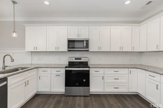 a kitchen with white cabinets and stainless steel appliances