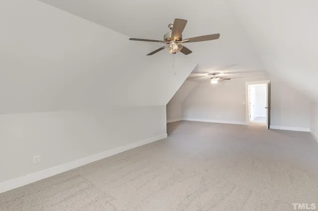 a view of a big room with staircase and a ceiling fan