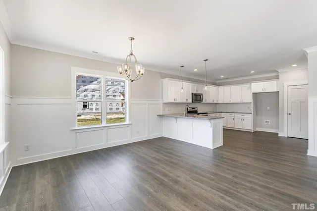 a view of kitchen with granite countertop cabinets and refrigerator