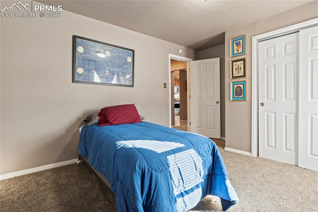 905 Prairie Road Colorado Springs, CO 80909 - Photo 9 of 21 a bedroom with a bed and painting on the wall
