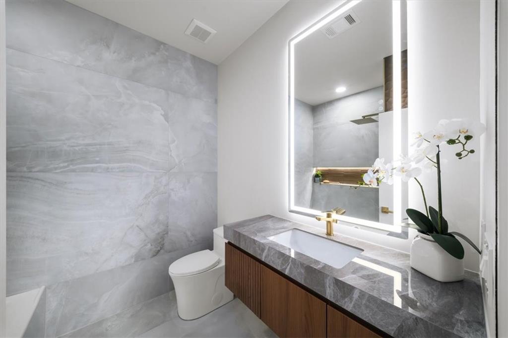 172 Racine Street Southwest Atlanta, GA 30314 - Photo 13 of 32 a bathroom with a granite countertop sink a toilet and a mirror