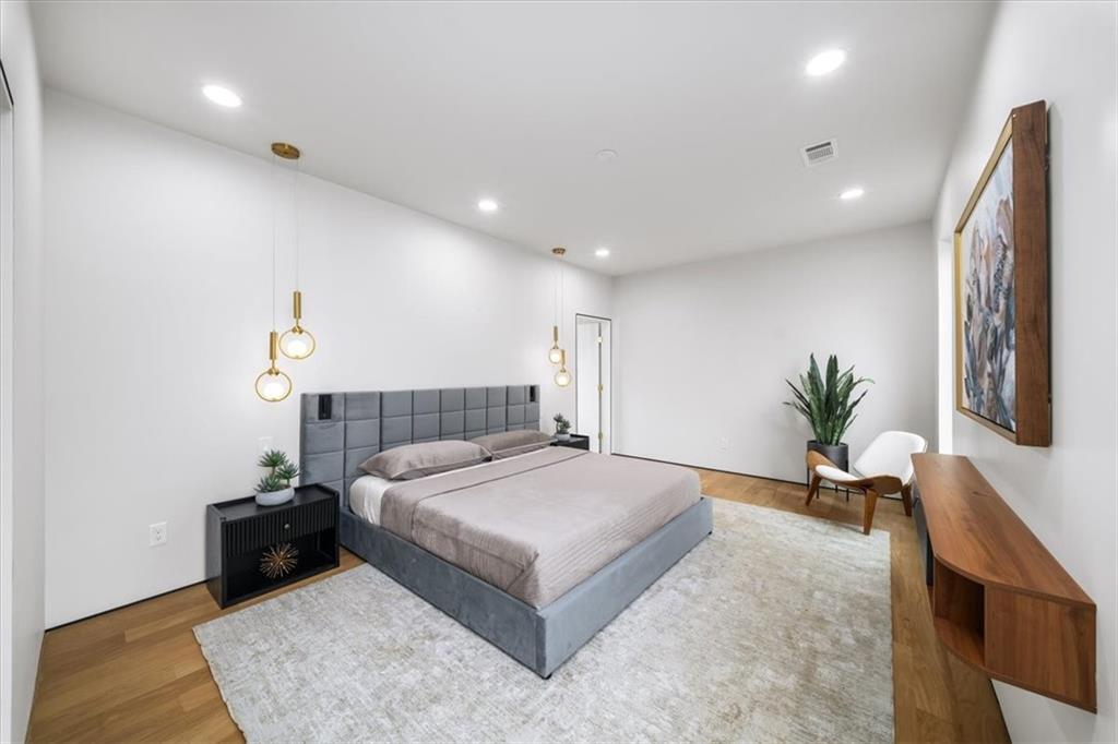 172 Racine Street Southwest Atlanta, GA 30314 - Photo 18 of 32 a bedroom with a large bed and a chandelier