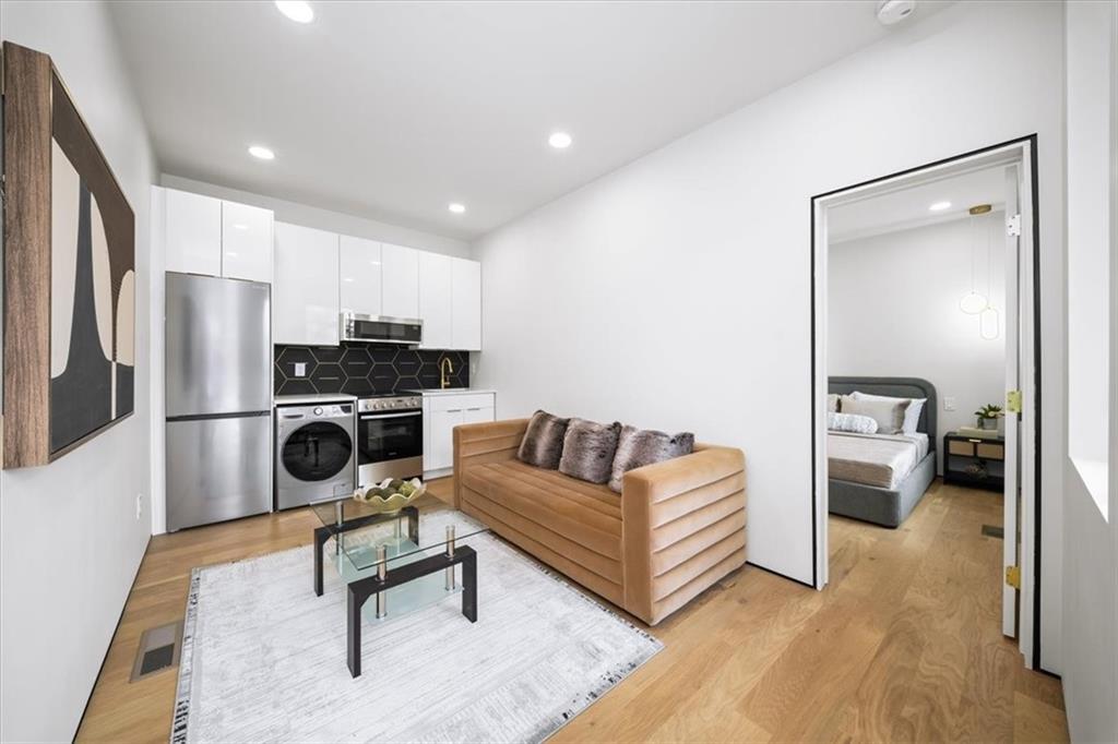 172 Racine Street Southwest Atlanta, GA 30314 - Photo 28 of 32 a living room with stainless steel appliances furniture a rug and a view of kitchen