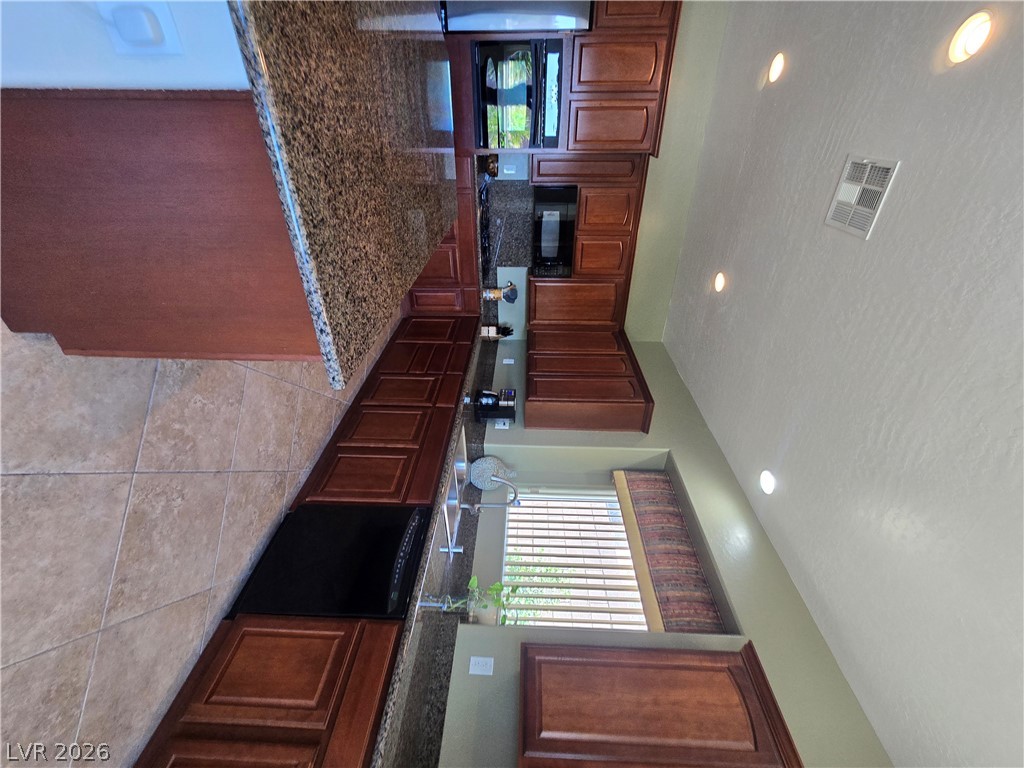 2567 Dirleton Place Henderson, NV 89044 - Photo 12 of 67 Culinary delights await in this well-appointed kitchen featuring rich wood cabinetry and ample counter space.