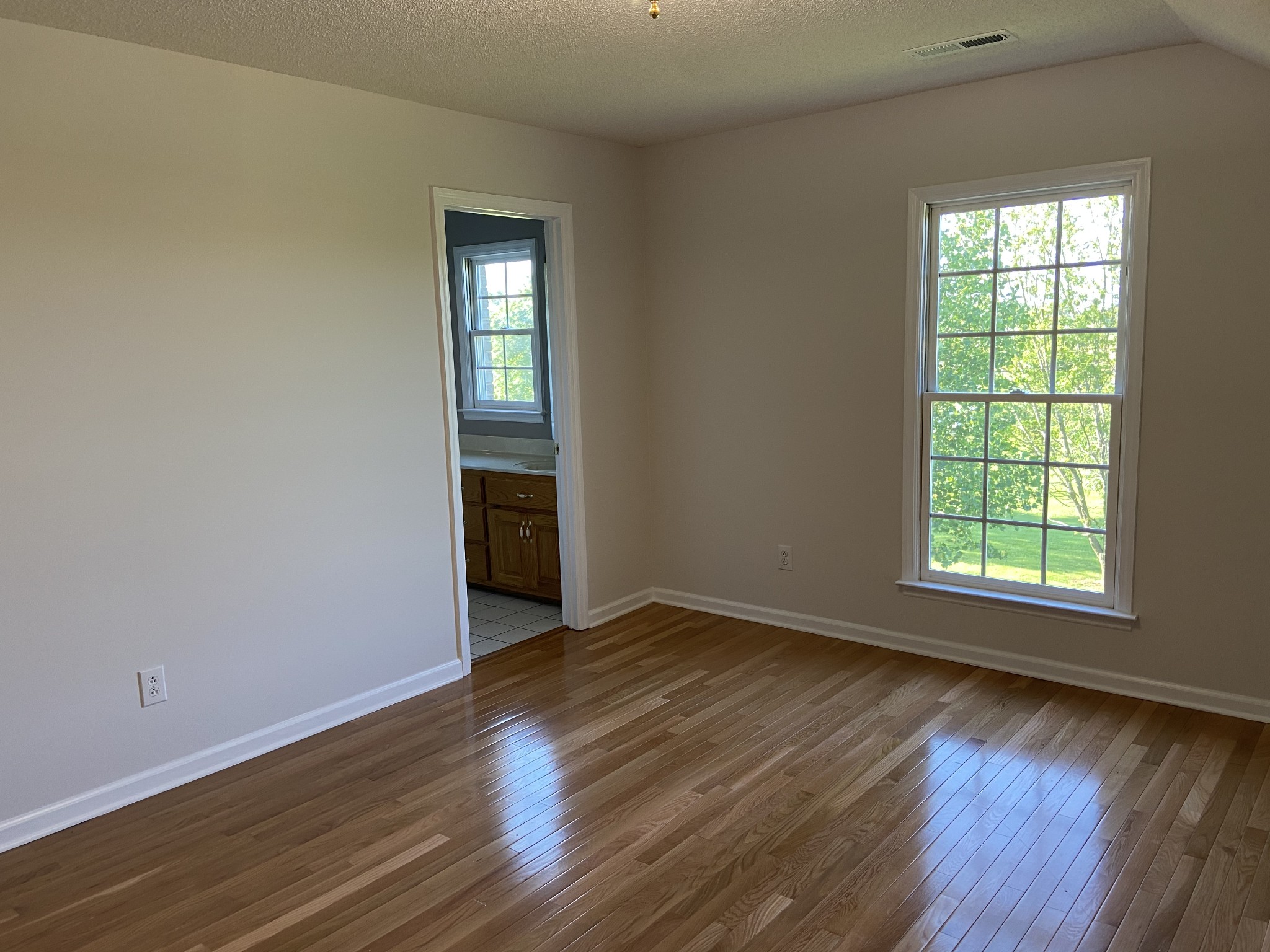 1370 Shelly Road Decherd, TN 37324 - Photo 34 of 44 an empty room with wooden floor and windows