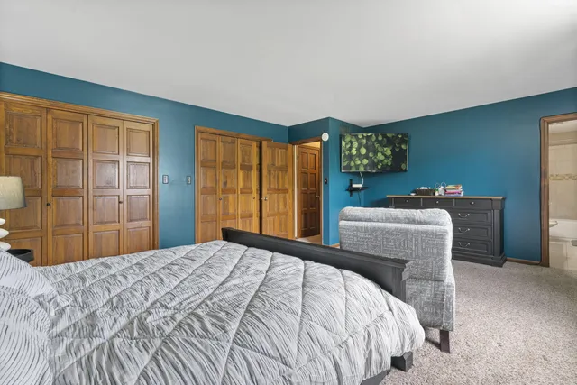 a bathroom with double vanity sinks a toilet a mirror and shower