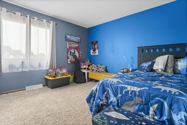 a bedroom with a bed and a couch next to a window