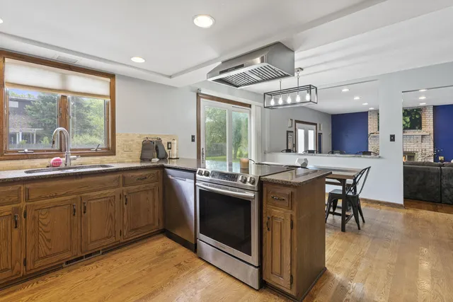 a kitchen with stainless steel appliances granite countertop a refrigerator a stove a sink and a refrigerator