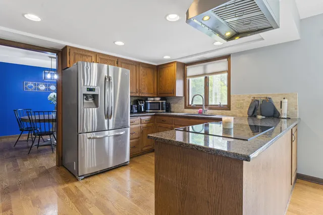 a kitchen with stainless steel appliances granite countertop a sink a stove and cabinets