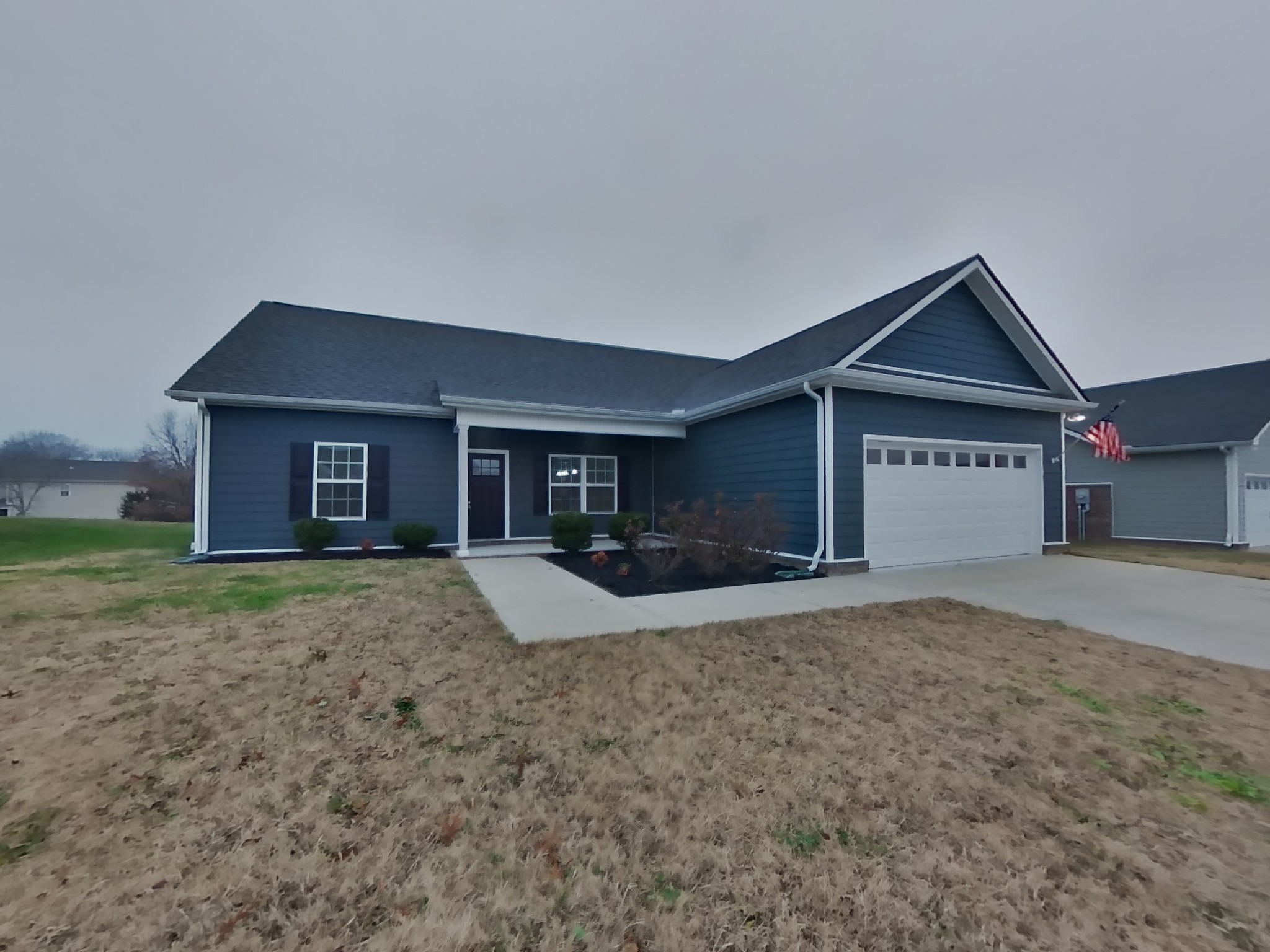 a view of a house with a yard and large tree
