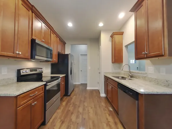 a kitchen with stainless steel appliances granite countertop a sink stove and refrigerator