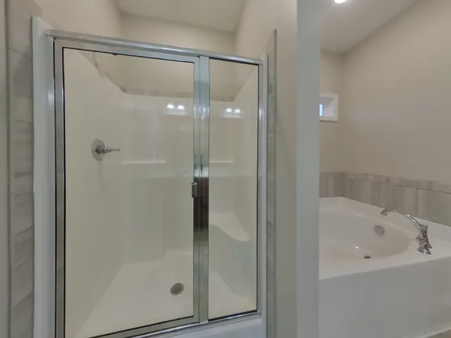 a bathroom with a glass shower door and a bathtub