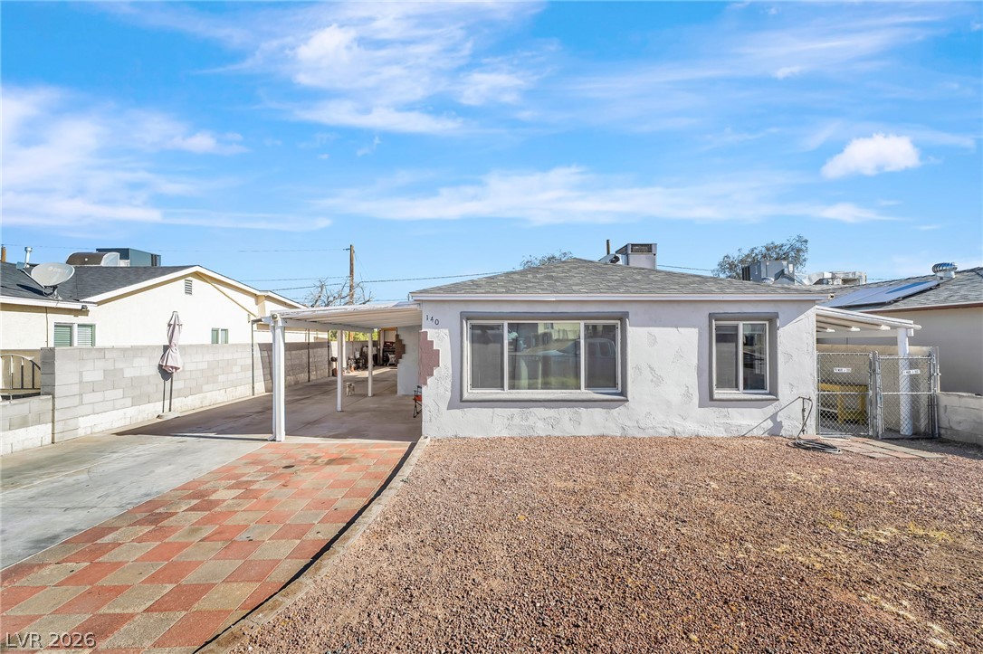 140 West Victory Road Henderson, NV 89015 - Photo 17 of 24 A modest home with a checkered driveway and a gravel front yard, offering practical outdoor living.