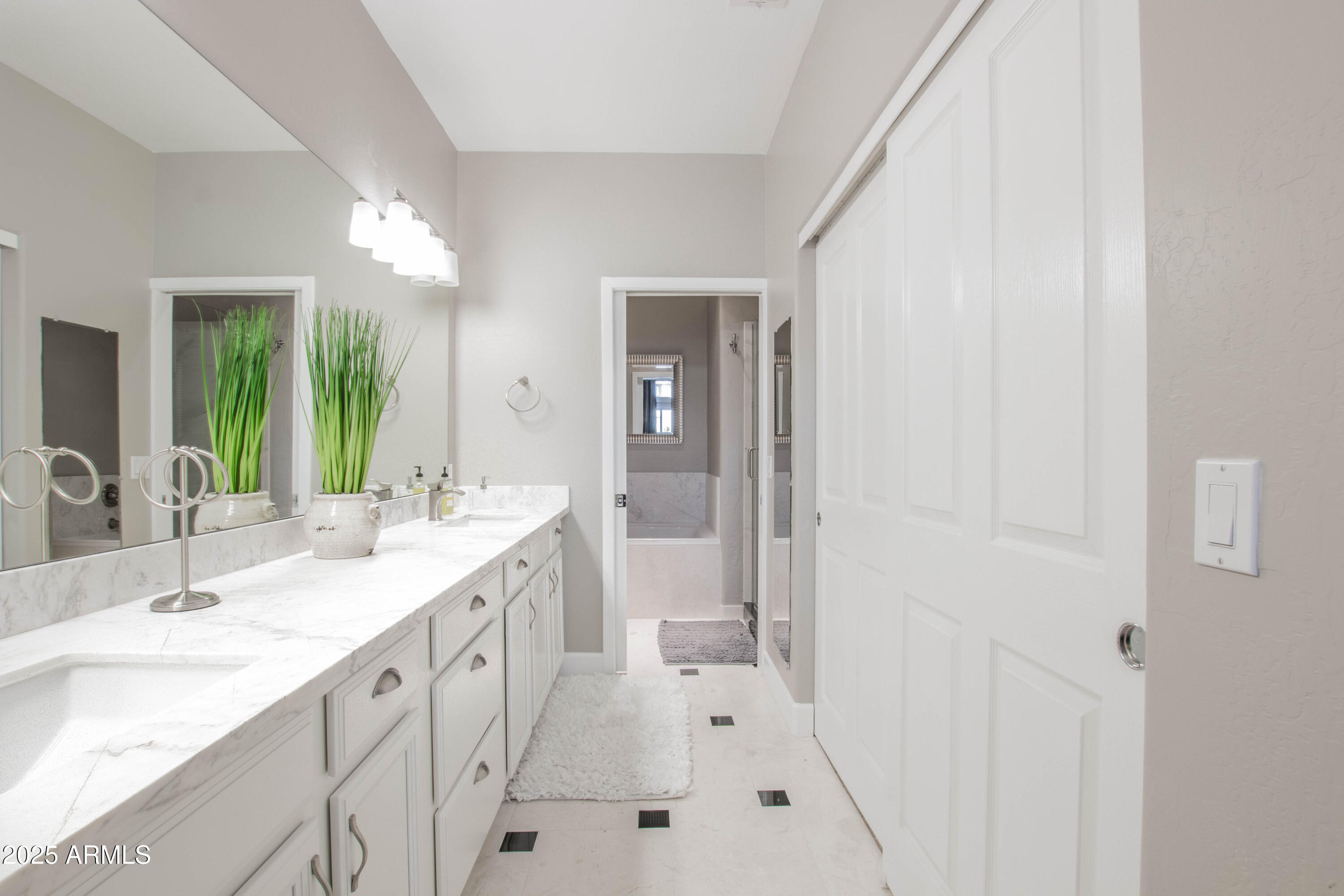 11260 North 92nd Street, Unit 1107 Scottsdale, AZ 85260 - Photo 11 of 20 a spacious bathroom with a double vanity sink a mirror and a bathtub