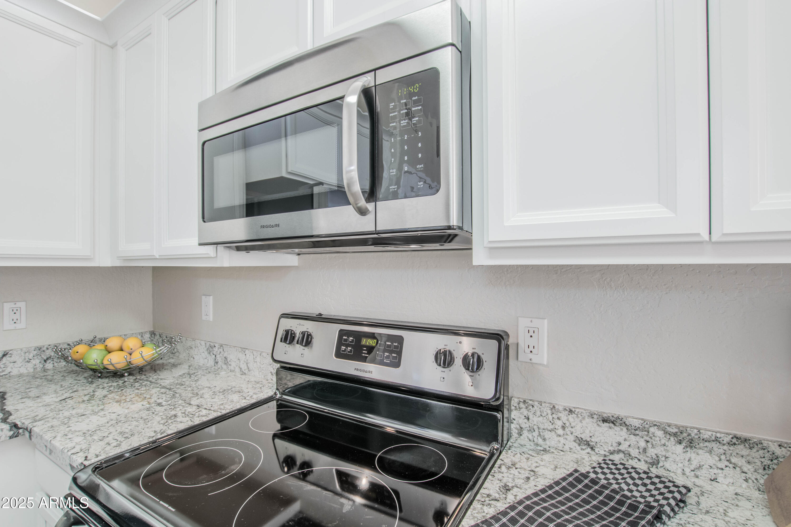 11260 North 92nd Street, Unit 1107 Scottsdale, AZ 85260 - Photo 7 of 20 a kitchen with a stove and a microwave