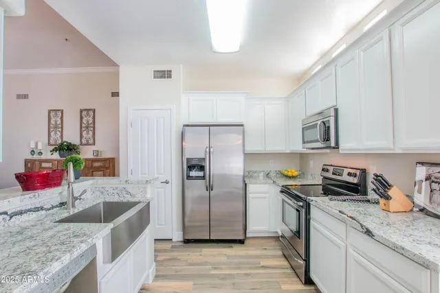 a kitchen with stainless steel appliances granite countertop a sink dishwasher stove and refrigerator