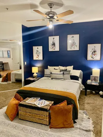 a spacious bedroom with a bed and a chandelier