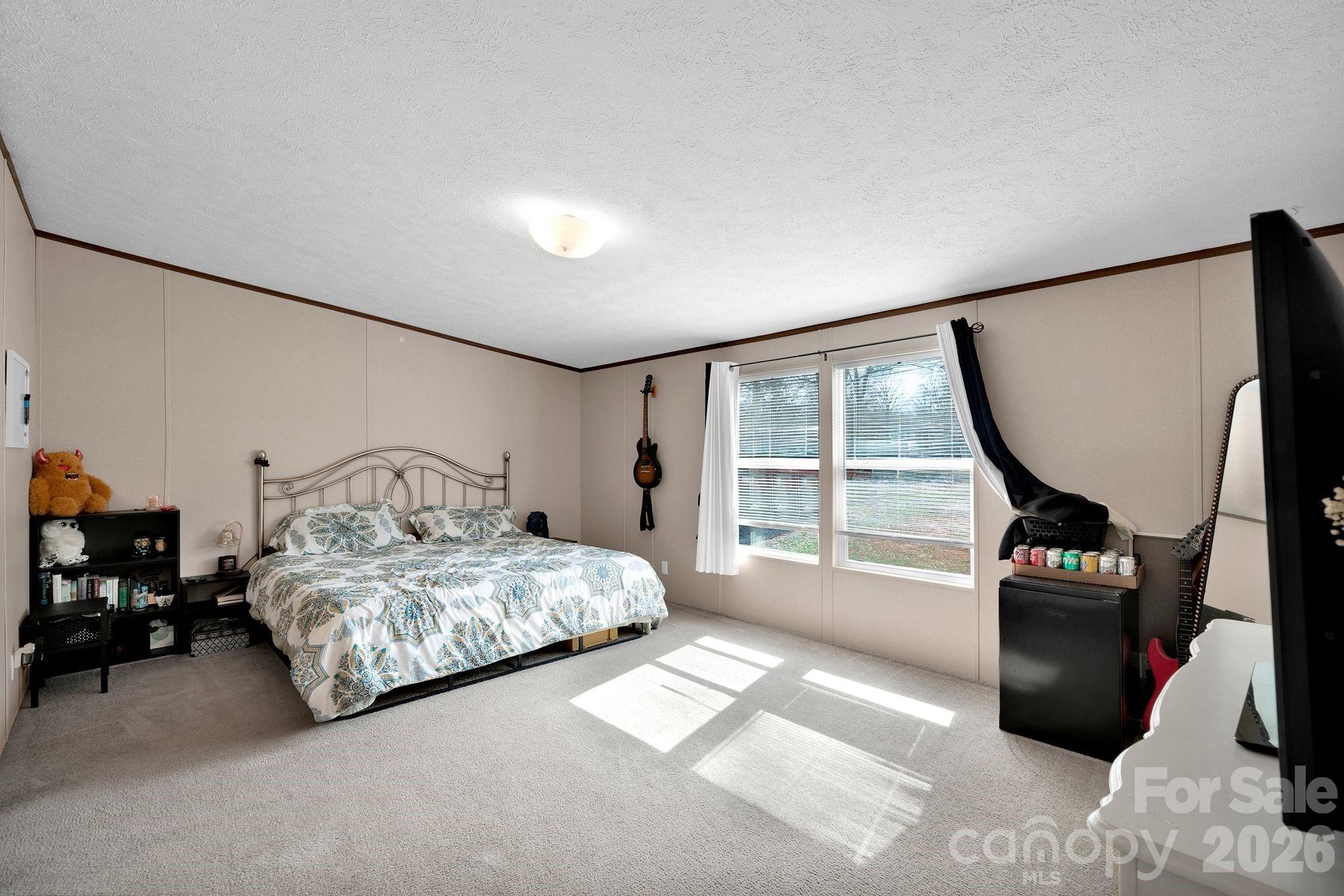 812 Dallas Spencer Mountain Road Dallas, NC 28034 - Photo 21 of 35 a bedroom with a bed a mirror and a large window