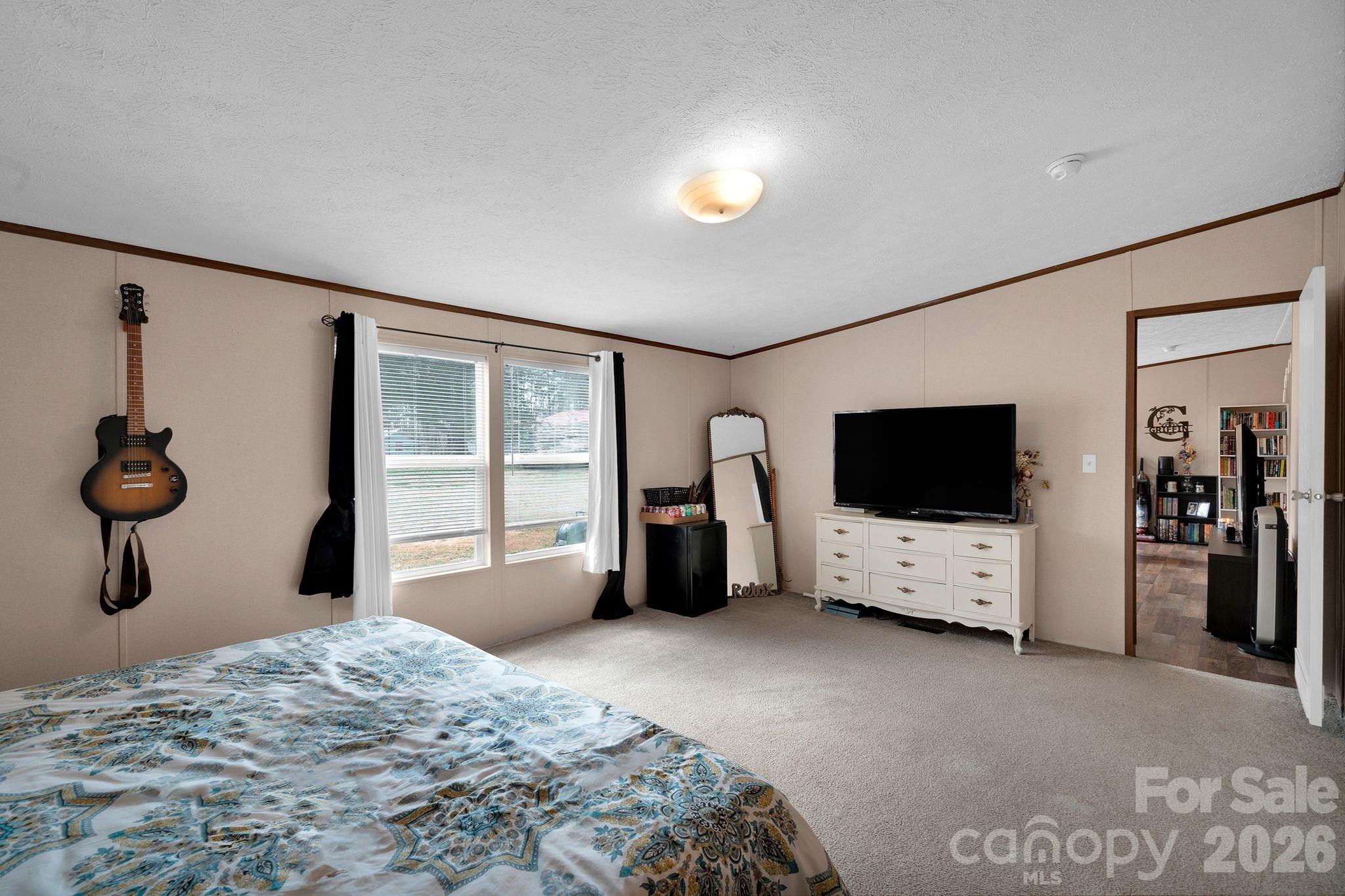 812 Dallas Spencer Mountain Road Dallas, NC 28034 - Photo 22 of 35 a bedroom with a bed and a flat tv screen on wall