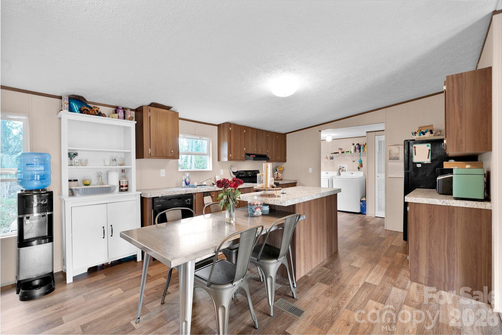 812 Dallas Spencer Mountain Road Dallas, NC 28034 - Photo 6 of 35 a kitchen with stainless steel appliances kitchen island granite countertop a table chairs and a refrigerator