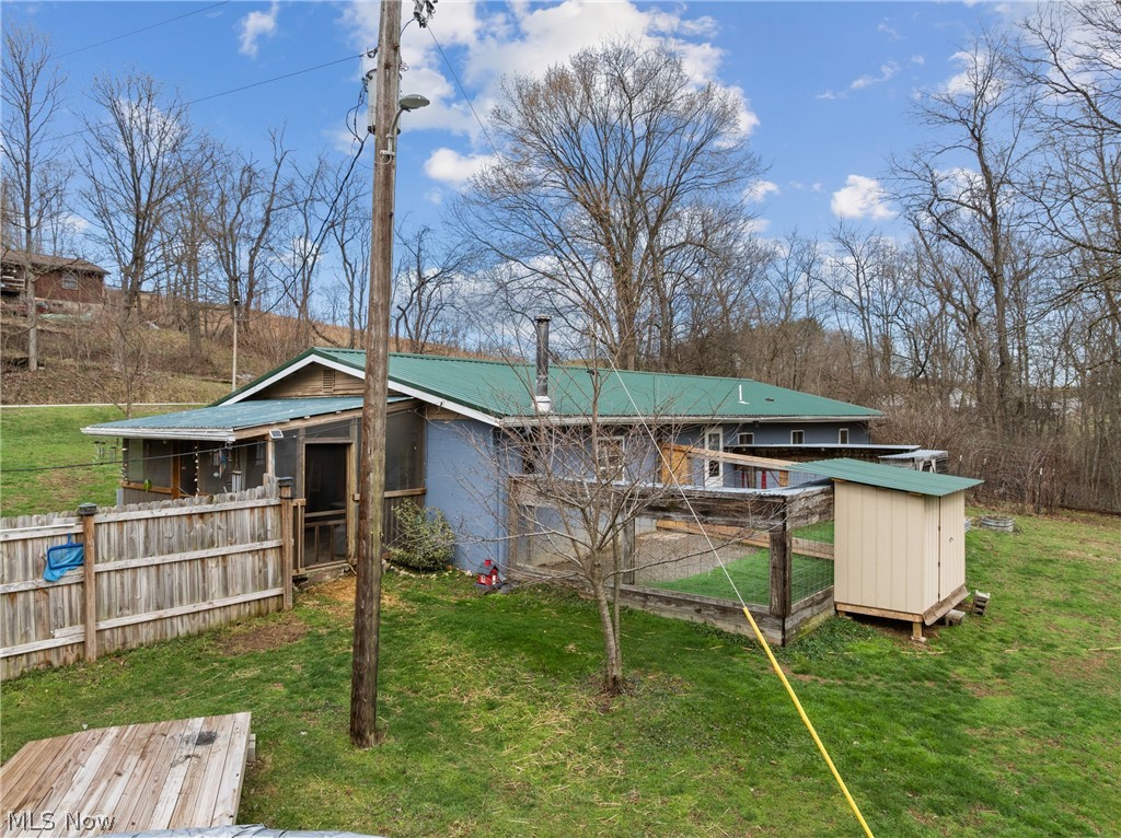 38340 Lees Run Road Cadiz, OH 43907 - Photo 24 of 31 Back of house with a metal roof, an outbuilding, exterior structure, and a lawn