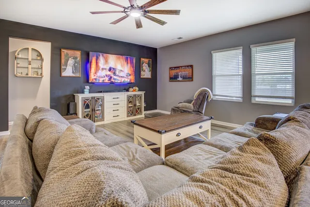 a living room with furniture a window and a flat screen tv