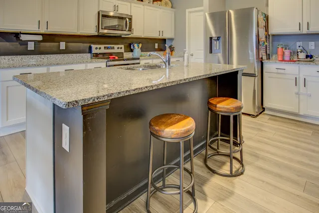 a kitchen with a sink a table and chairs in it