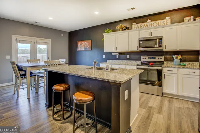 a kitchen with a sink cabinets and wooden floor