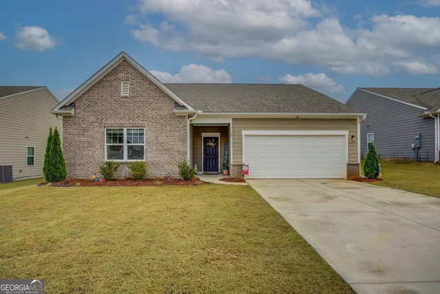 front view of a house with a yard and garage