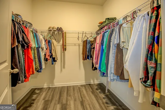 a view of walk in closet with clothes and shoes