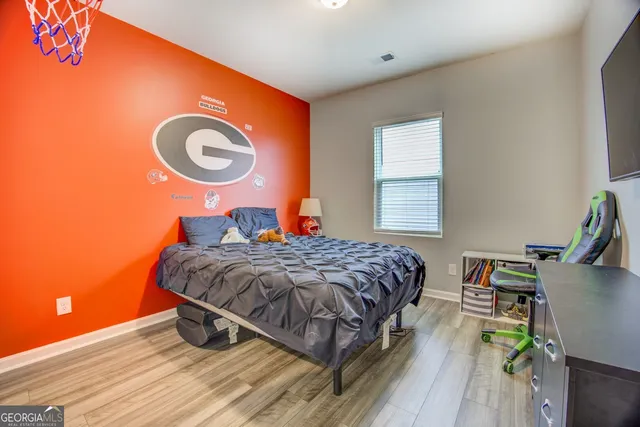 a bedroom with a bed and a table with wooden floor