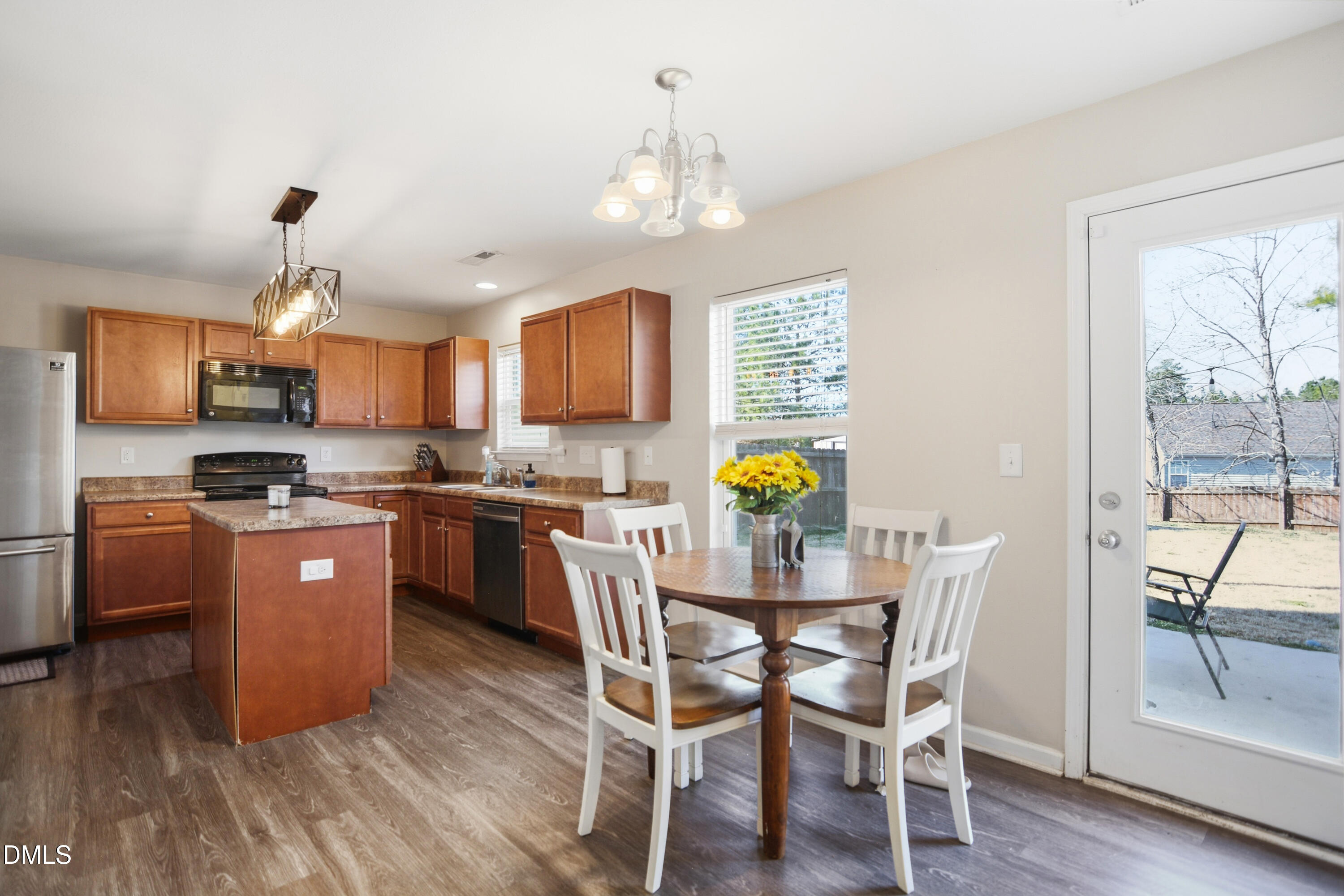 Undisclosed Address Durham, NC 27704 - Photo 9 of 21 a kitchen with stainless steel appliances granite countertop a refrigerator a stove a sink dishwasher a dining table and chairs with wooden floor