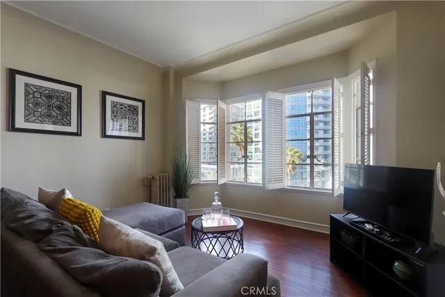 a living room with furniture a flat screen tv and a window