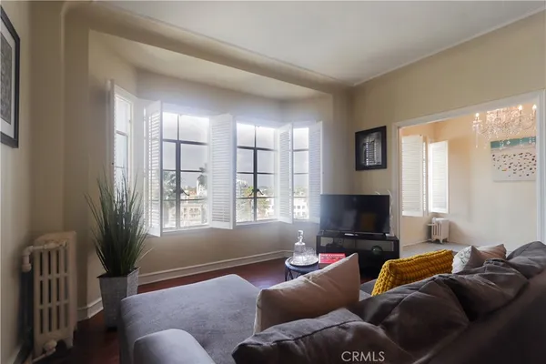 a living room with furniture a flat screen tv and a window
