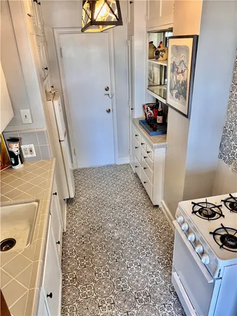 a kitchen with a stove a refrigerator a sink and wooden floor