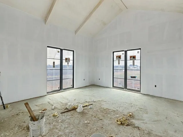 an empty room with closet and windows