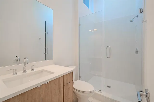 a bathroom with a sink toilet vanity and shower