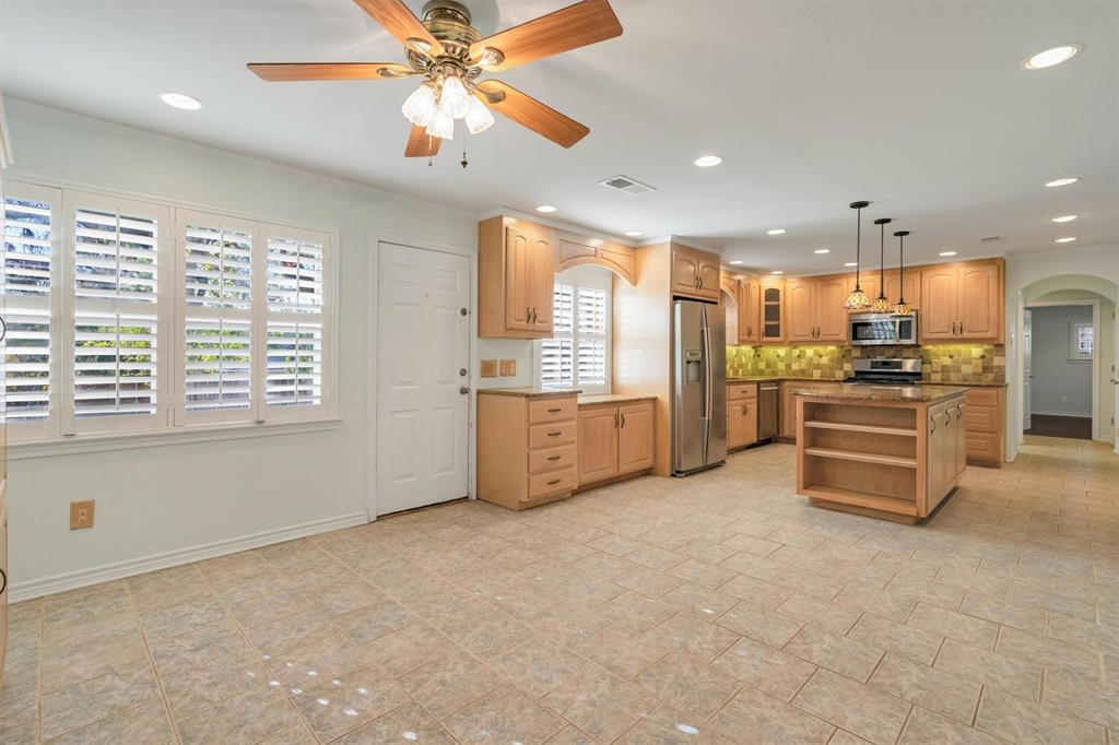 1832 Wonderlight Lane Dallas, TX 75228 - Photo 11 of 39 a large kitchen with stainless steel appliances a stove a refrigerator a oven with white cabinets and couches