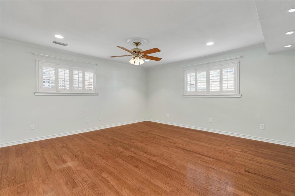 1832 Wonderlight Lane Dallas, TX 75228 - Photo 20 of 39 an empty room with wooden floor and a ceiling fan